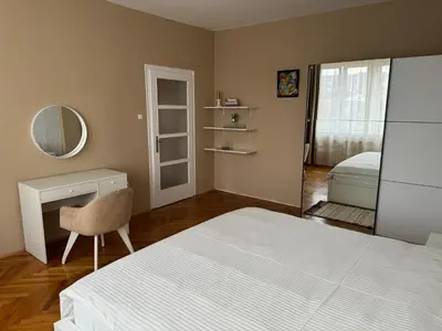 a bedroom with a bed and a desk and a mirror at Trident Apartments 3 in Niš