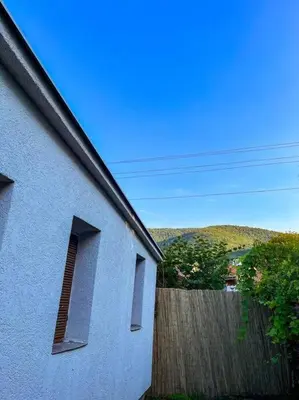 a white building with two windows and a fence at Villa Lenka Sokobanja in Soko Banja