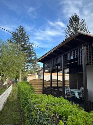a building with a fence next to a hedge at Villa Lenka Sokobanja in Soko Banja