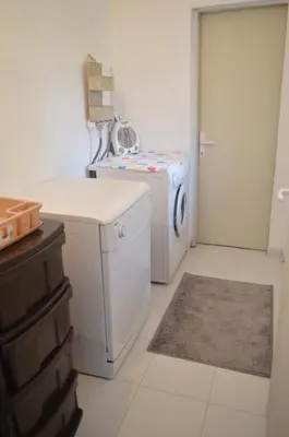 a white laundry room with a washer and dryer at Kuca Rancic in Pirot