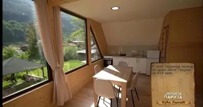 a kitchen with a table and a large window at Kuca Rancic in Pirot