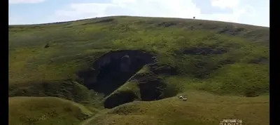 a hill with a cave in the middle of a field at Kuca Rancic in Pirot