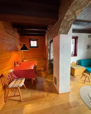 a dining room with a table and a couch at Planinska kuća Savić, Kopaonik in Kopaonik