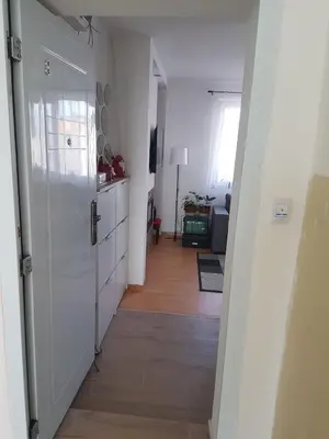 a hallway leading to a kitchen with a white door at Apartman VUK in Pirot
