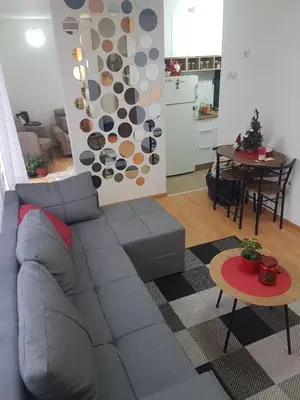 a living room with a gray couch and a table at Apartman VUK in Pirot