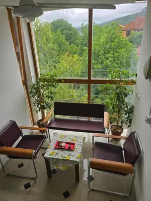 a living room with two chairs and a table and a large window at APARTMANSKI SMEŠTAJ SOLARIS kod Aqua Parka Yuth Studio in Soko Banja