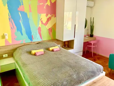 a bedroom with a bed with two pillows on it at Happy Sweet Apartment in Niš