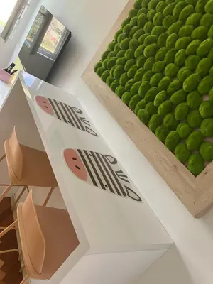 a table with a green wall of green balls at Happy Sweet Apartment in Niš