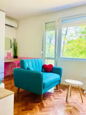 a living room with a blue couch and a table at Happy Sweet Apartment in Niš