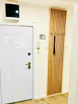 a white door with a television on a wall at Happy Sweet Apartment in Niš