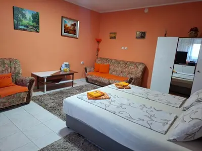 a living room with a large bed and a couch at Nela Apartmani in Niš