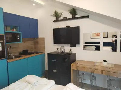 a kitchen with blue cabinets and a table with chairs at N Lux 95 Milmari in Kopaonik