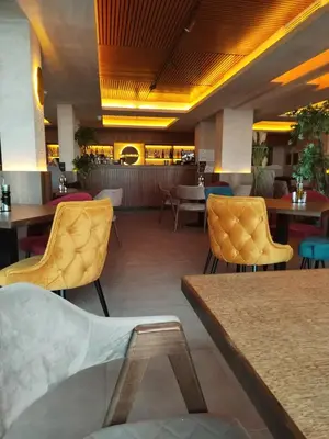 a restaurant with yellow chairs and tables and tables at N Lux 95 Milmari in Kopaonik