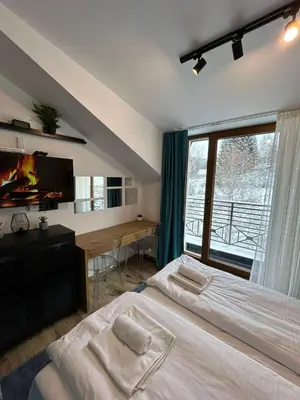 a bedroom with two beds and a tv and a window at N Lux 95 Milmari in Kopaonik