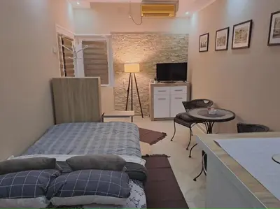 a bedroom with a bed and a table and a television at Golden Star Viktor in Zaječar