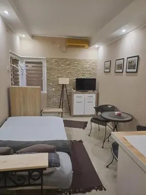 a bedroom with a bed and a table and a tv at Golden Star Viktor in Zaječar
