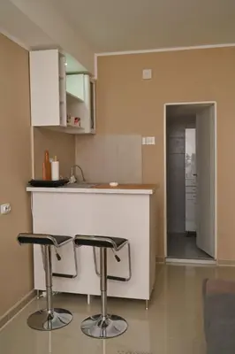 a kitchen with a counter and two bar stools at Golden Star Viktor in Zaječar