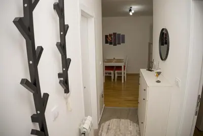 a room with a hallway with white walls and a table at Apartment Infinity in Kruševac