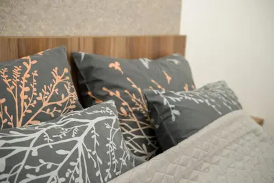 a pile of pillows sitting on top of a bed at Apartment Infinity in Kruševac