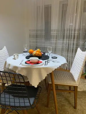 a white table with a bowl of fruit on it at OLI apartman in Niš