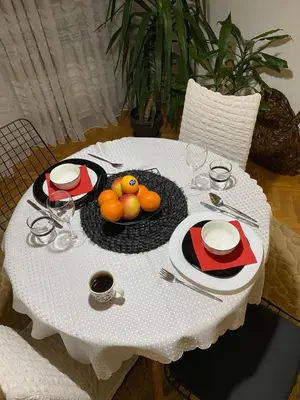 a white table with a plate of fruit on it at OLI apartman in Niš
