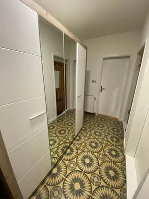 a hallway with a mirror and a tile floor at OLI apartman in Niš