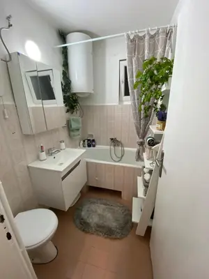 a bathroom with a toilet and a sink and a tub at OLI apartman in Niš