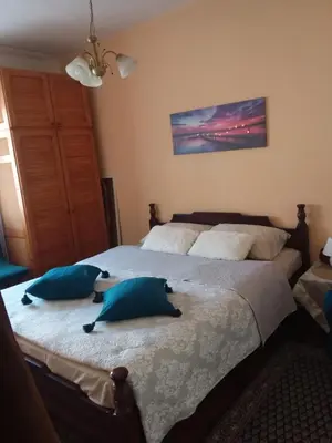 a bedroom with a large bed with blue pillows at Ikaria in Niš