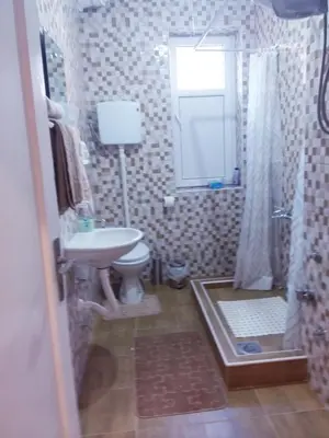 a bathroom with a sink and a toilet and a mirror at Ikaria in Niš
