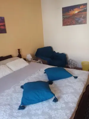 two blue pillows on a bed in a room at Ikaria in Niš