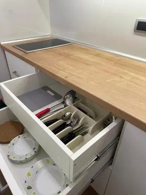 a kitchen counter with a white drawer with utensils at N Apartment in Vrnjačka Banja