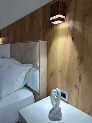 a bedroom with a bed with a alarm clock on a table at N Apartment in Vrnjačka Banja