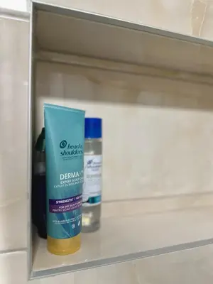 a shelf with a bottle of cleaning products on it at N Apartment in Vrnjačka Banja