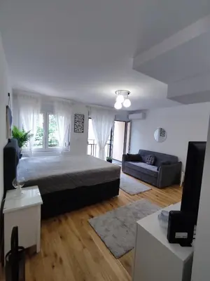 a bedroom with a large bed and a couch at GALEB in Vrnjačka Banja