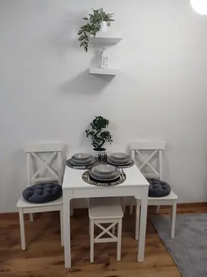 a white table with plates on it with two chairs at GALEB in Vrnjačka Banja