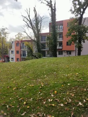 a grassy hill in front of an apartment building at GALEB in Vrnjačka Banja