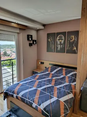 a bedroom with a bed and a balcony at Apartman Gold in Vrnjačka Banja