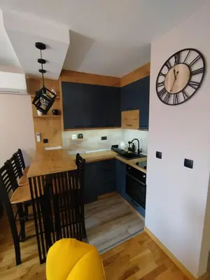 a kitchen with a large clock on the wall at Apartman Gold in Vrnjačka Banja