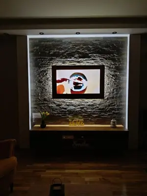 a tv in a room with a brick wall at Apartman Gold in Vrnjačka Banja