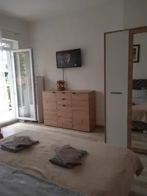 a bedroom with a bed and a dresser with a television at MAL Apartman in Soko Banja