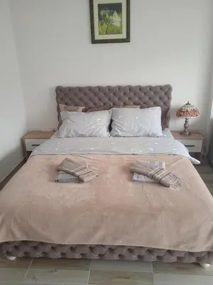 a bedroom with a bed with two towels on it at MAL Apartman in Soko Banja