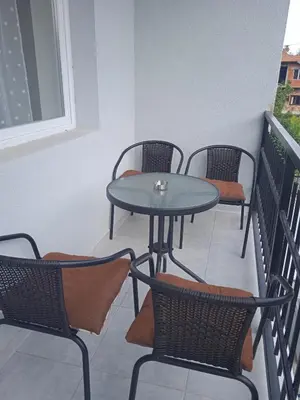 a patio table and chairs on a balcony at MAL Apartman in Soko Banja