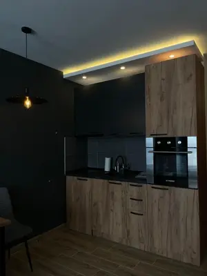 a kitchen with wooden cabinets and a stove top oven at M&Alux Kopaonik in Cajetina