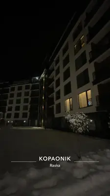 a night view of a tall building at night at M&Alux Kopaonik in Cajetina