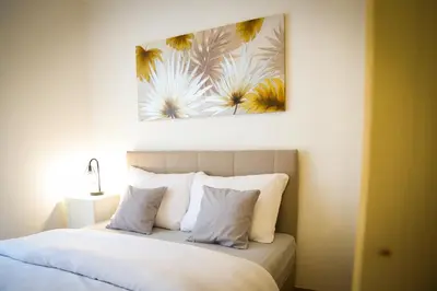 a bedroom with a bed with a painting on the wall at Apartman IRIS in Vrnjačka Banja