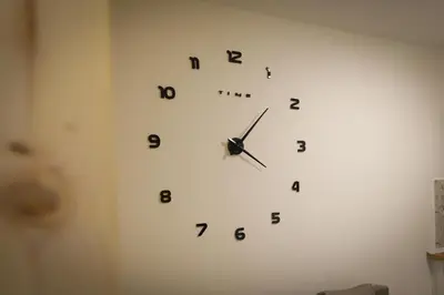 a white clock on a wall with numbers on it at Apartman IRIS in Vrnjačka Banja