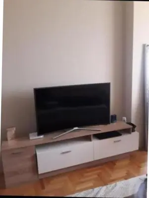 a flat screen tv sitting on top of a white entertainment center at TEA APARTMAN in Niš