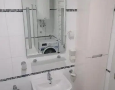 a bathroom with a sink and a mirror with a camera at TEA APARTMAN in Niš