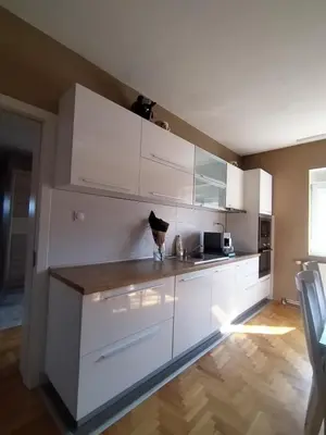 a kitchen with white cabinets and a counter top at TEA APARTMAN in Niš