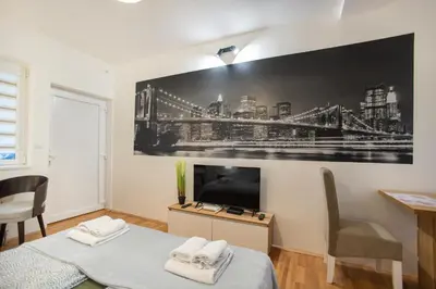 a bedroom with a large picture of a bridge on the wall at V & V Studio Apartments 2 in Niš